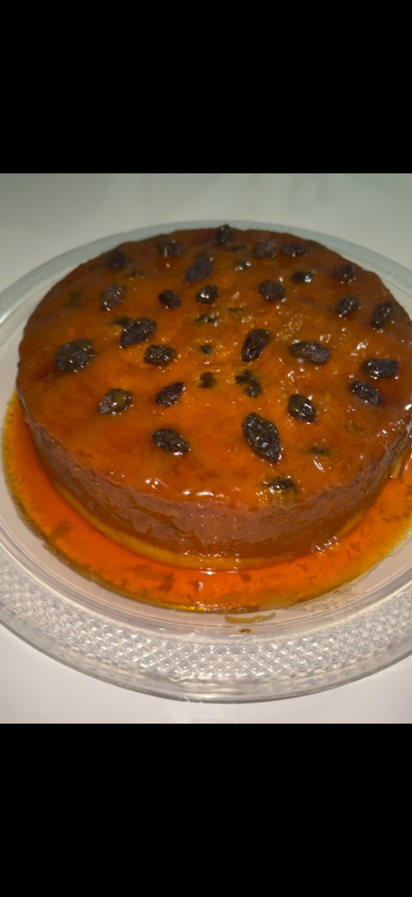 Pudín con pasas y caramelo sobre un plato transparente